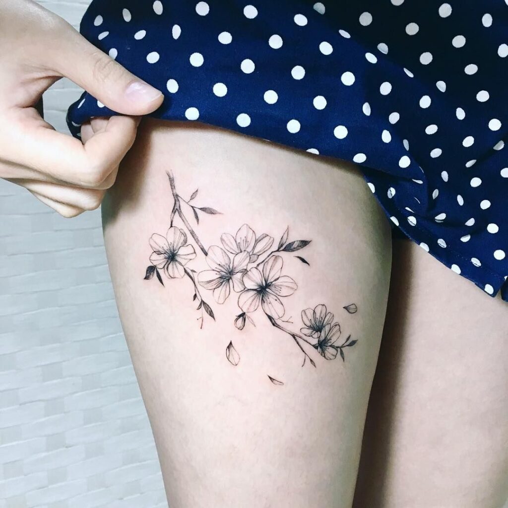 Tatuagem na perna feminina delicada com flor 